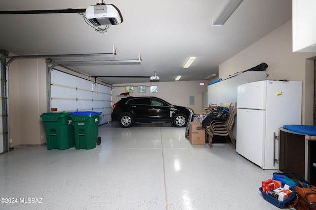 garage with a garage door opener and white fridge