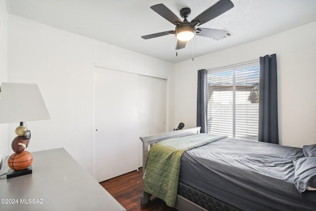 bedroom featuring ceiling fan, dark hardwood / wood-style flooring, and a closet