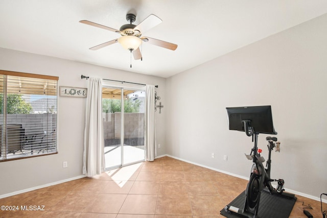 exercise room featuring ceiling fan and light tile patterned flooring