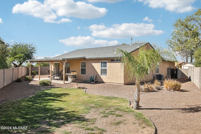 back of house with a yard, cooling unit, and a patio area