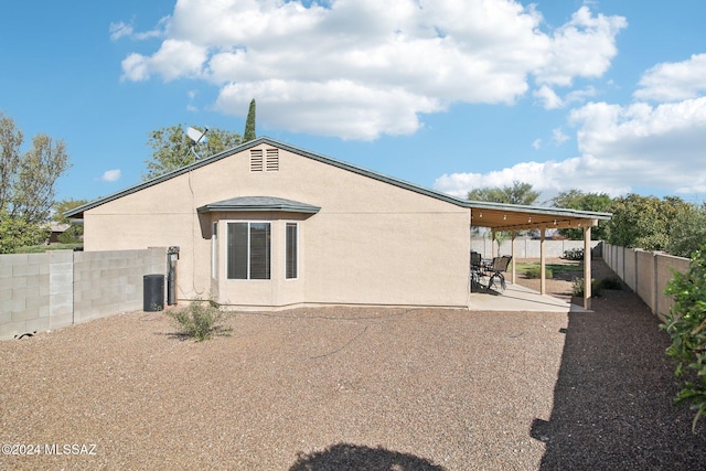 back of property featuring a patio and a carport