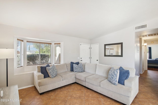 living room with tile patterned flooring and lofted ceiling