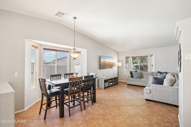 tiled dining area with vaulted ceiling