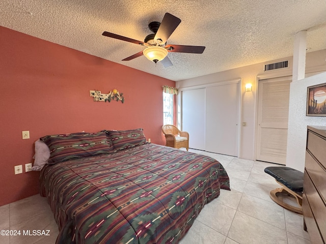 tiled bedroom with a textured ceiling, a closet, and ceiling fan