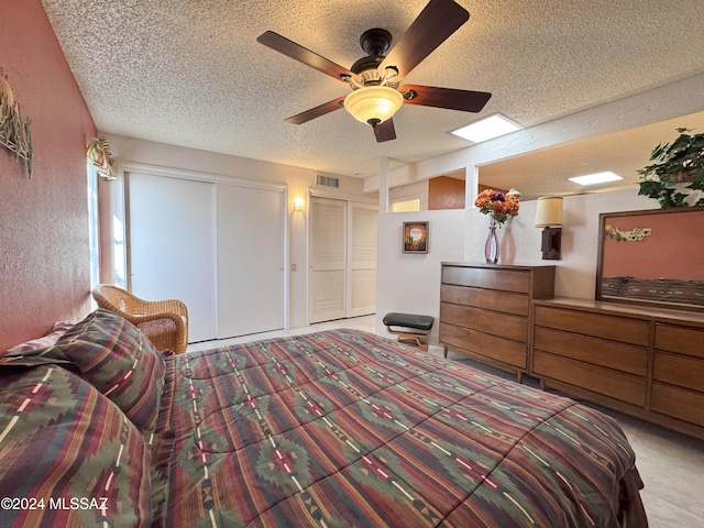 bedroom with ceiling fan and a textured ceiling