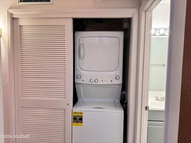 washroom featuring stacked washer / dryer