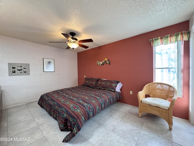 bedroom with ceiling fan, a textured ceiling, and brick wall