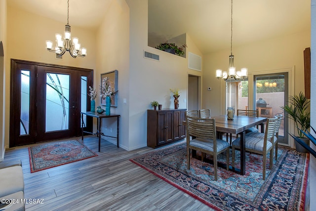 dining area featuring high vaulted ceiling, a healthy amount of sunlight, and an inviting chandelier