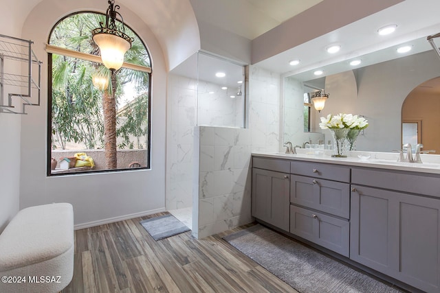 bathroom with a shower, hardwood / wood-style floors, vanity, and a healthy amount of sunlight