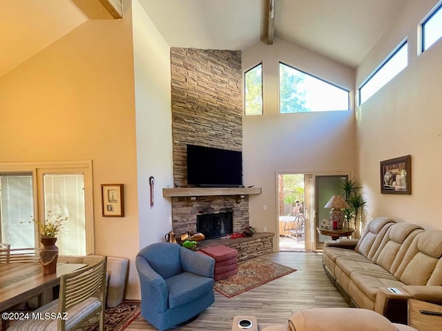 living room with a fireplace, beam ceiling, light hardwood / wood-style floors, and high vaulted ceiling