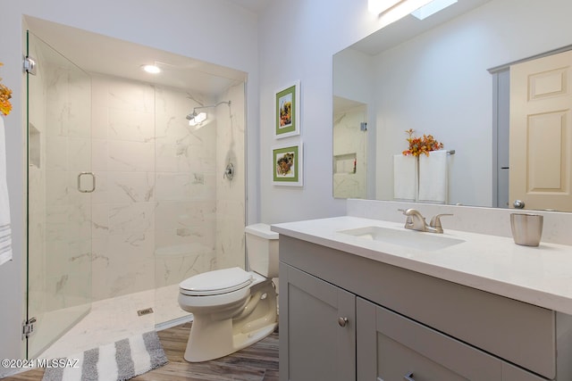 bathroom featuring a skylight, walk in shower, wood-type flooring, toilet, and vanity