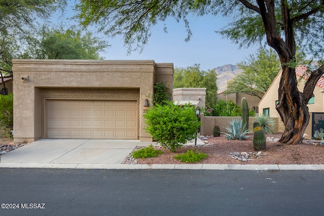 pueblo-style home featuring a mountain view and a garage