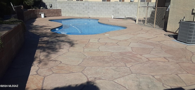 view of swimming pool featuring central AC unit and a patio