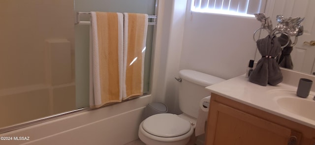 full bathroom featuring vanity, combined bath / shower with glass door, and toilet