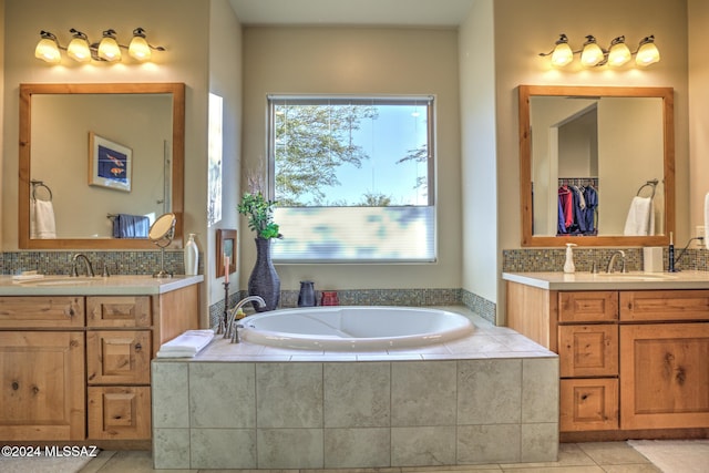 bathroom featuring tile patterned floors, tiled tub, and vanity