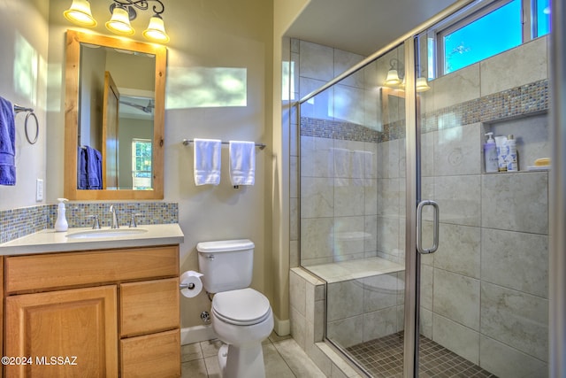 bathroom featuring backsplash, vanity, tile patterned flooring, toilet, and a shower with shower door