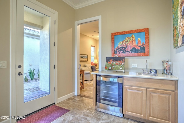 bar featuring wine cooler, crown molding, sink, and light brown cabinetry