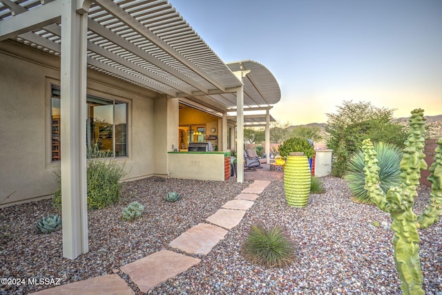 yard at dusk with a pergola and a patio