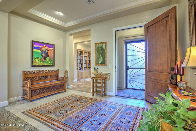 foyer with a raised ceiling, light tile patterned floors, and crown molding