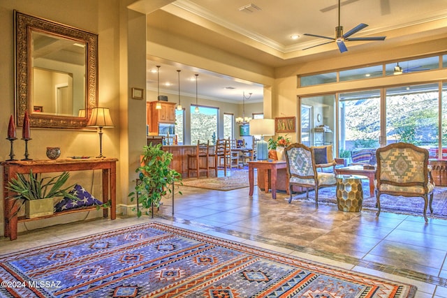 interior space featuring a wealth of natural light, crown molding, and ceiling fan with notable chandelier