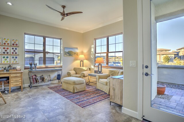 living area with ceiling fan and ornamental molding