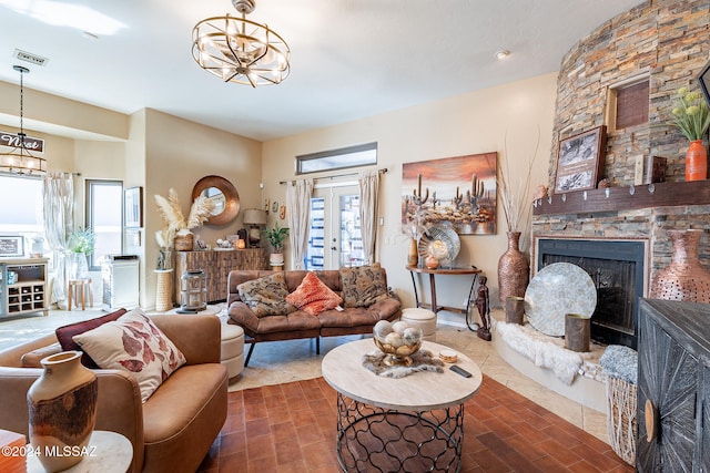 living room with a stone fireplace and an inviting chandelier