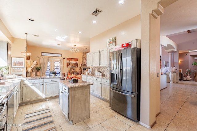 kitchen with stainless steel appliances, kitchen peninsula, a kitchen island, decorative columns, and pendant lighting