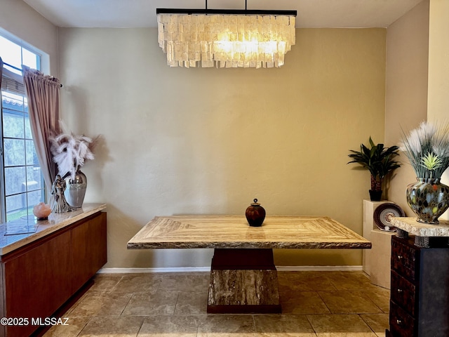 dining area featuring baseboards and an inviting chandelier