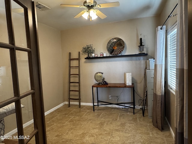 interior space with a ceiling fan, visible vents, and baseboards