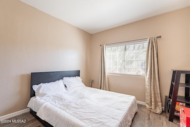 bedroom with wood finished floors and baseboards