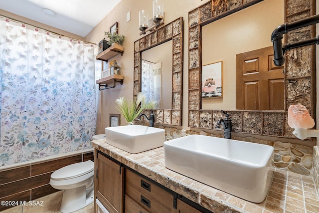 full bath with wainscoting, a sink, shower / bathtub combination with curtain, and toilet