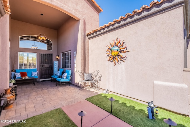 property entrance with a tiled roof, a patio, and stucco siding