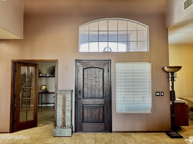 entryway featuring visible vents and a towering ceiling