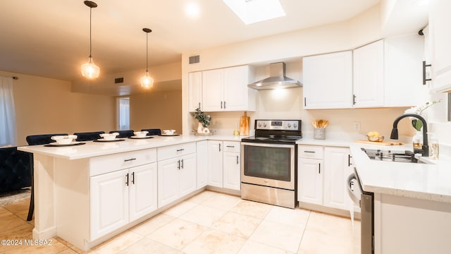 kitchen with appliances with stainless steel finishes, wall chimney exhaust hood, white cabinetry, and kitchen peninsula