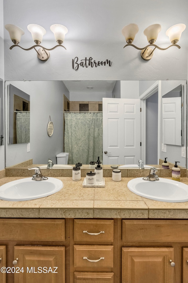 bathroom with toilet, vanity, and a shower with shower curtain