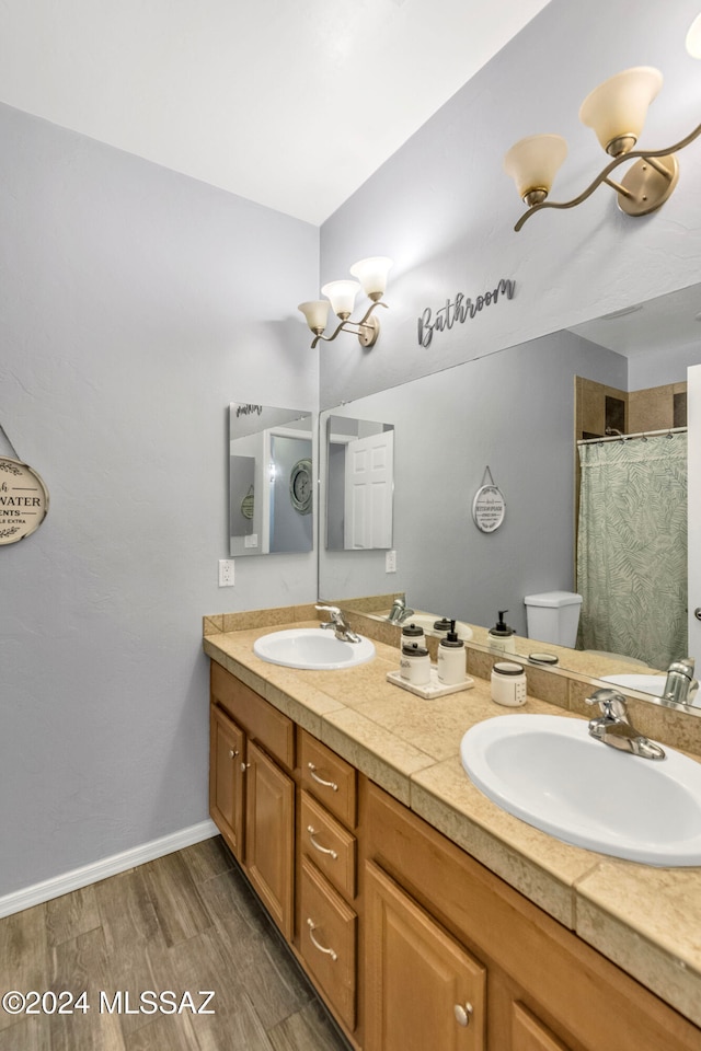 bathroom featuring hardwood / wood-style flooring, vanity, toilet, and walk in shower