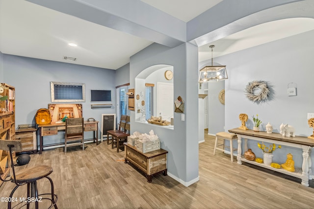 interior space with light wood-type flooring and an inviting chandelier