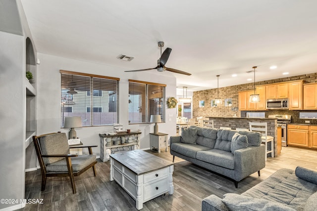 living room featuring ceiling fan, light hardwood / wood-style flooring, and plenty of natural light