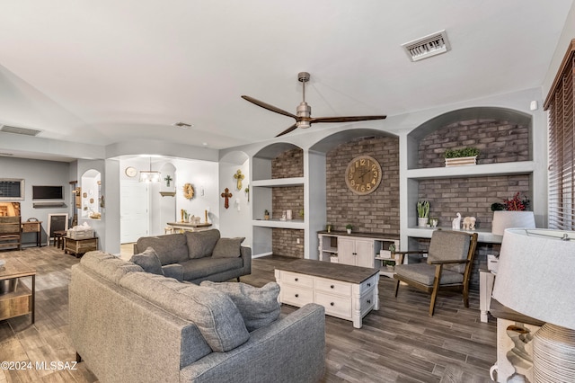 living room with a fireplace, dark hardwood / wood-style floors, built in features, and ceiling fan