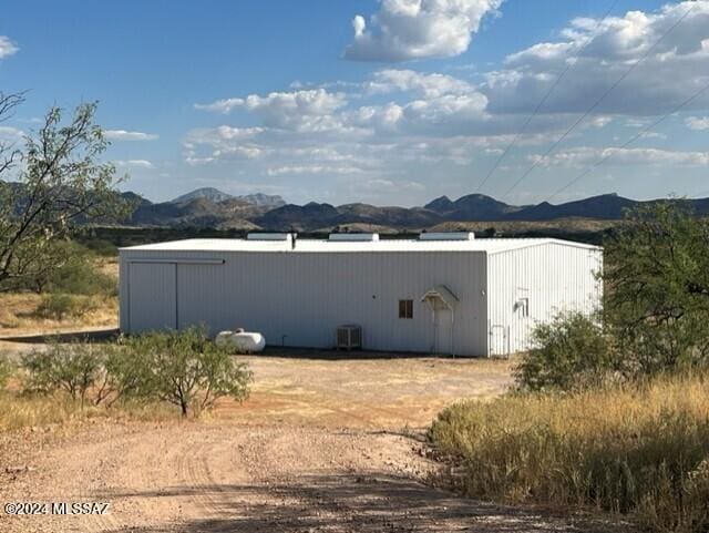 back of property with a mountain view and central AC unit