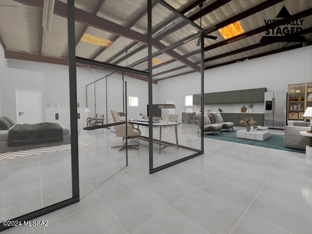 basement with light tile patterned floors and stainless steel fridge