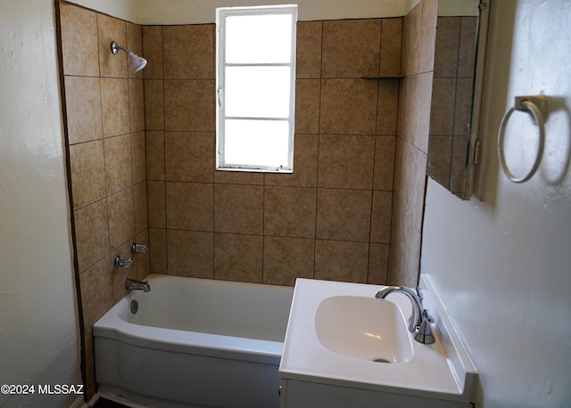 bathroom featuring tiled shower / bath combo and vanity