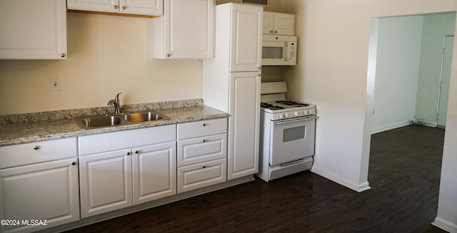 kitchen with white cabinets, dark hardwood / wood-style flooring, sink, and white appliances