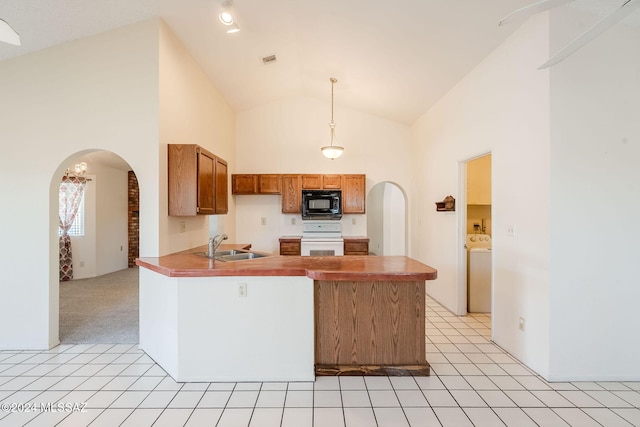 kitchen with white stove, hanging light fixtures, light carpet, sink, and high vaulted ceiling