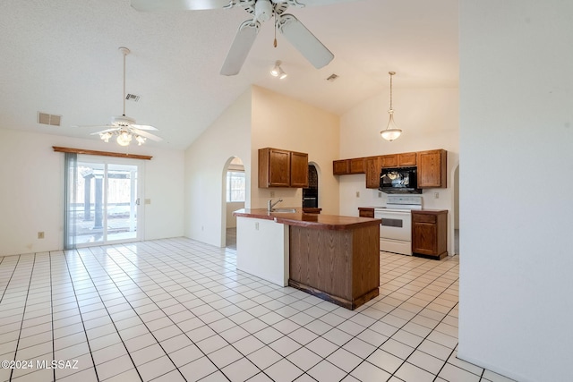 kitchen with white stove, kitchen peninsula, sink, high vaulted ceiling, and light tile patterned flooring