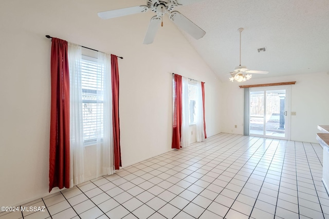 tiled empty room featuring ceiling fan, a textured ceiling, and vaulted ceiling