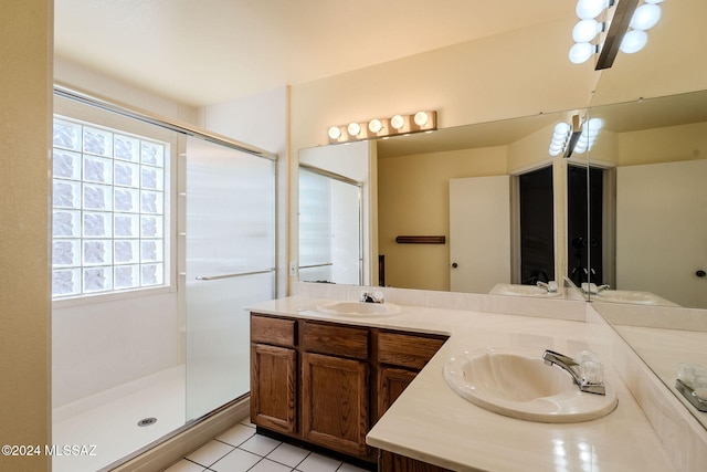 bathroom featuring vanity, a shower with shower door, and tile patterned flooring