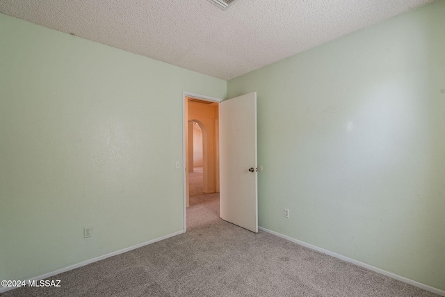 carpeted spare room featuring a textured ceiling