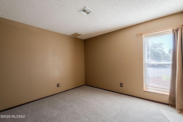 carpeted spare room featuring a textured ceiling