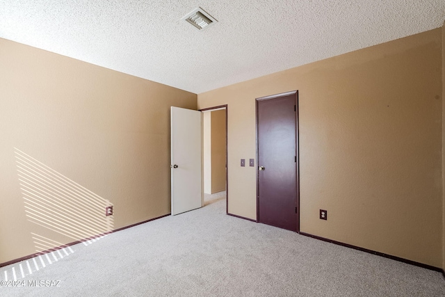 unfurnished bedroom with a textured ceiling and light carpet